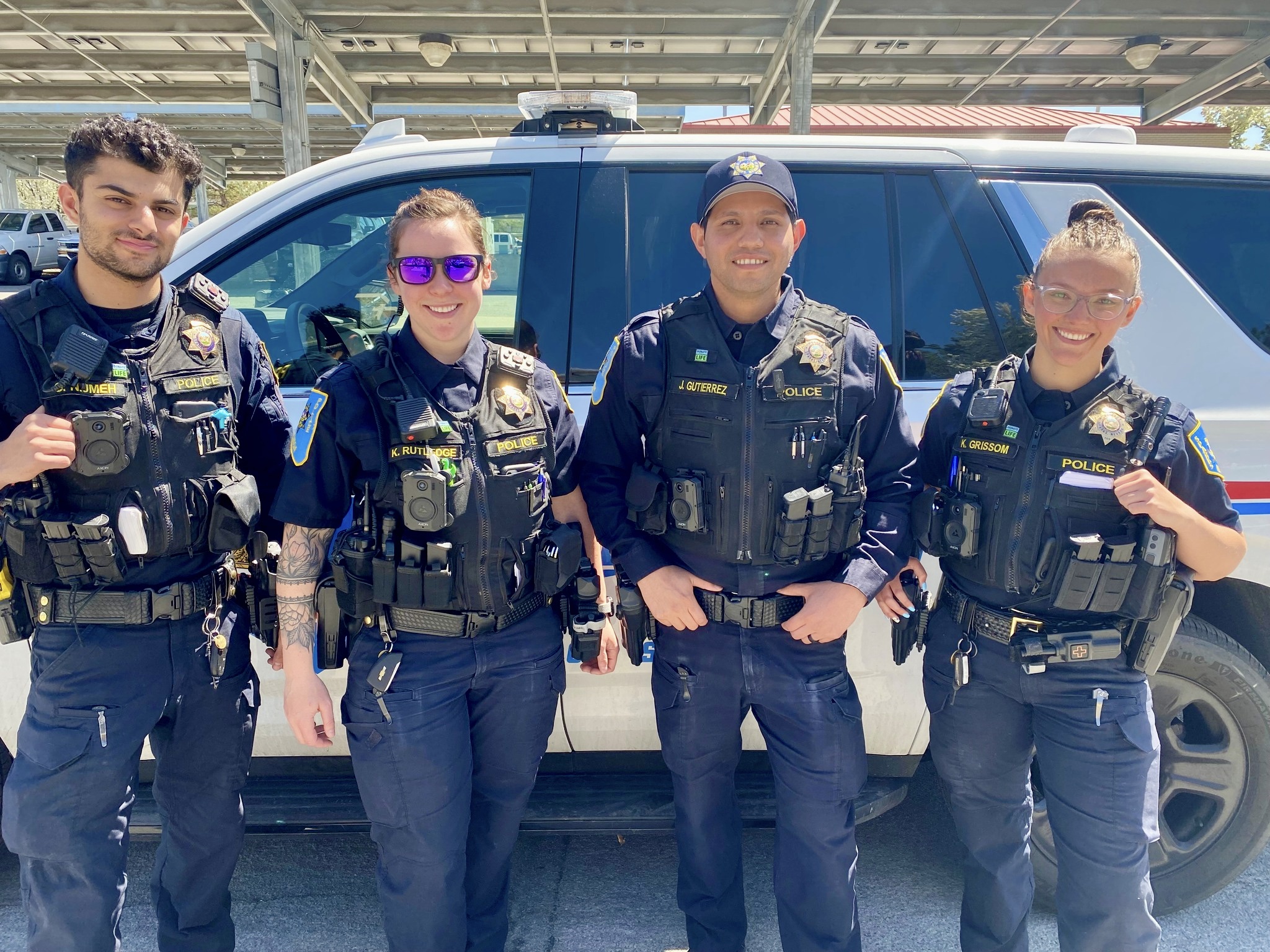 Four police officers stand beside a white van